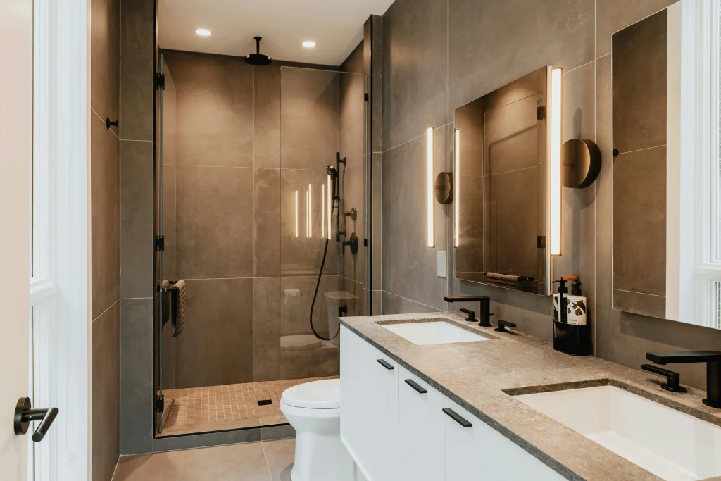 Professional tub-to-shower conversion in Aurora featuring a marble-walled walk-in shower with a glass door, custom floating wood vanity, and a modern freestanding tub.